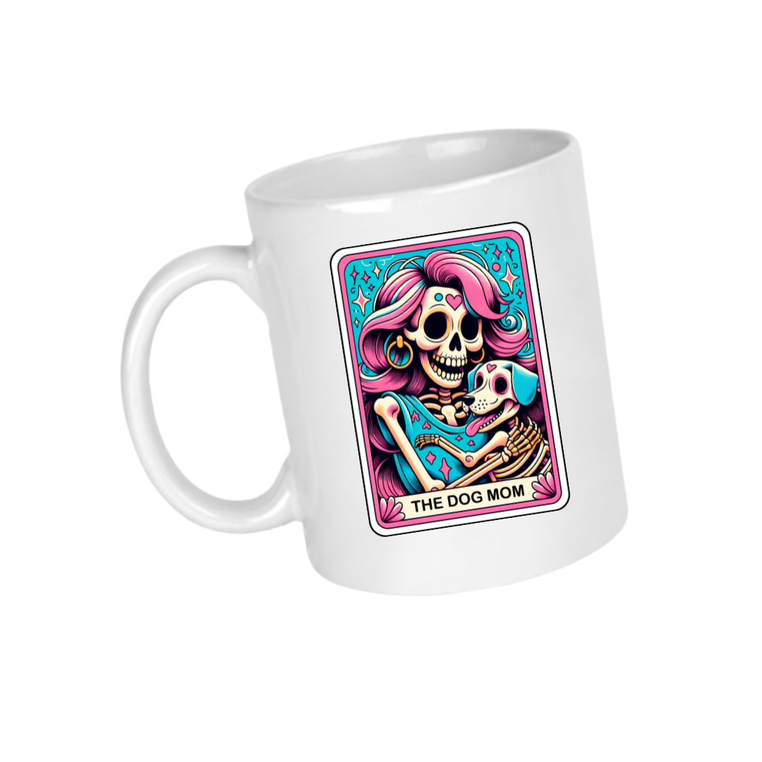 A ceramic mug with a colorful illustration of a skull with a dog, and the text 'THE DOG MOM'.