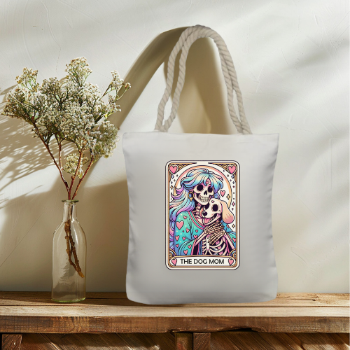 Tote bag with colorful skeleton design and 'The Dog Mom' text on a wooden surface with a vase of flowers.