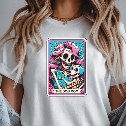 White t-shirt with a colorful graphic design featuring a skeleton and text 'THE DOG MOM' on a plain background.